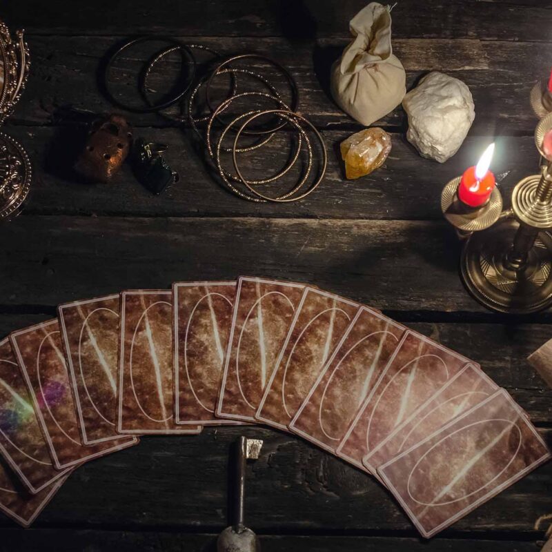 Psychic performing relationship insight reading with tarot cards and candles