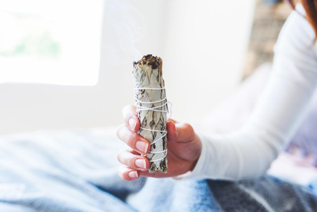 Spiritual cleansing ritual using herbs and smoke to remove negative energy